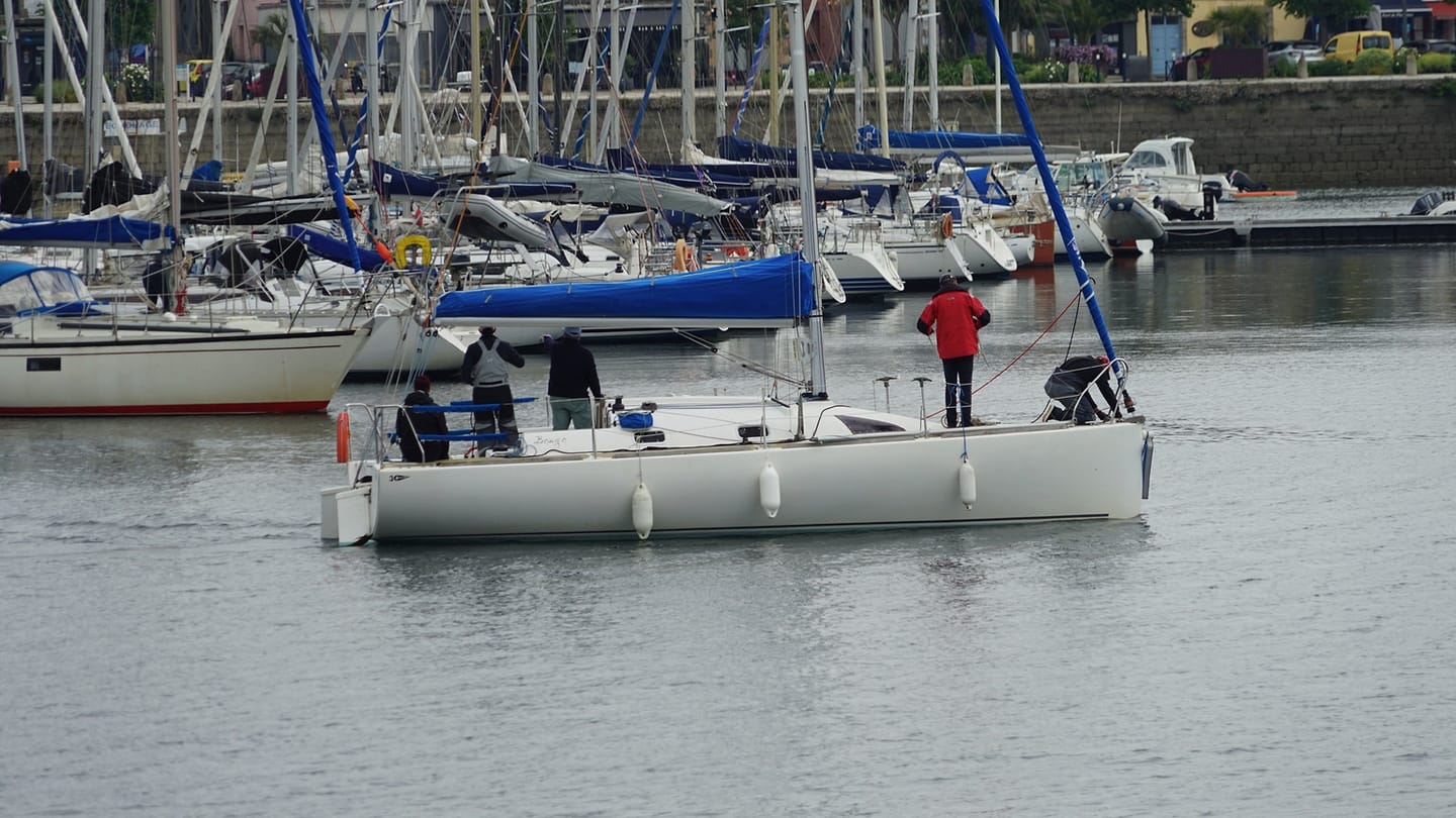 Beginner sailors sharing jobs in a yacht cockpit