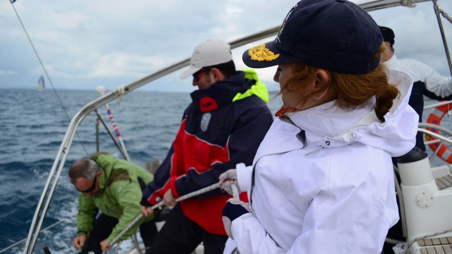 Crew practising coordinated line handling on a sailboat deck