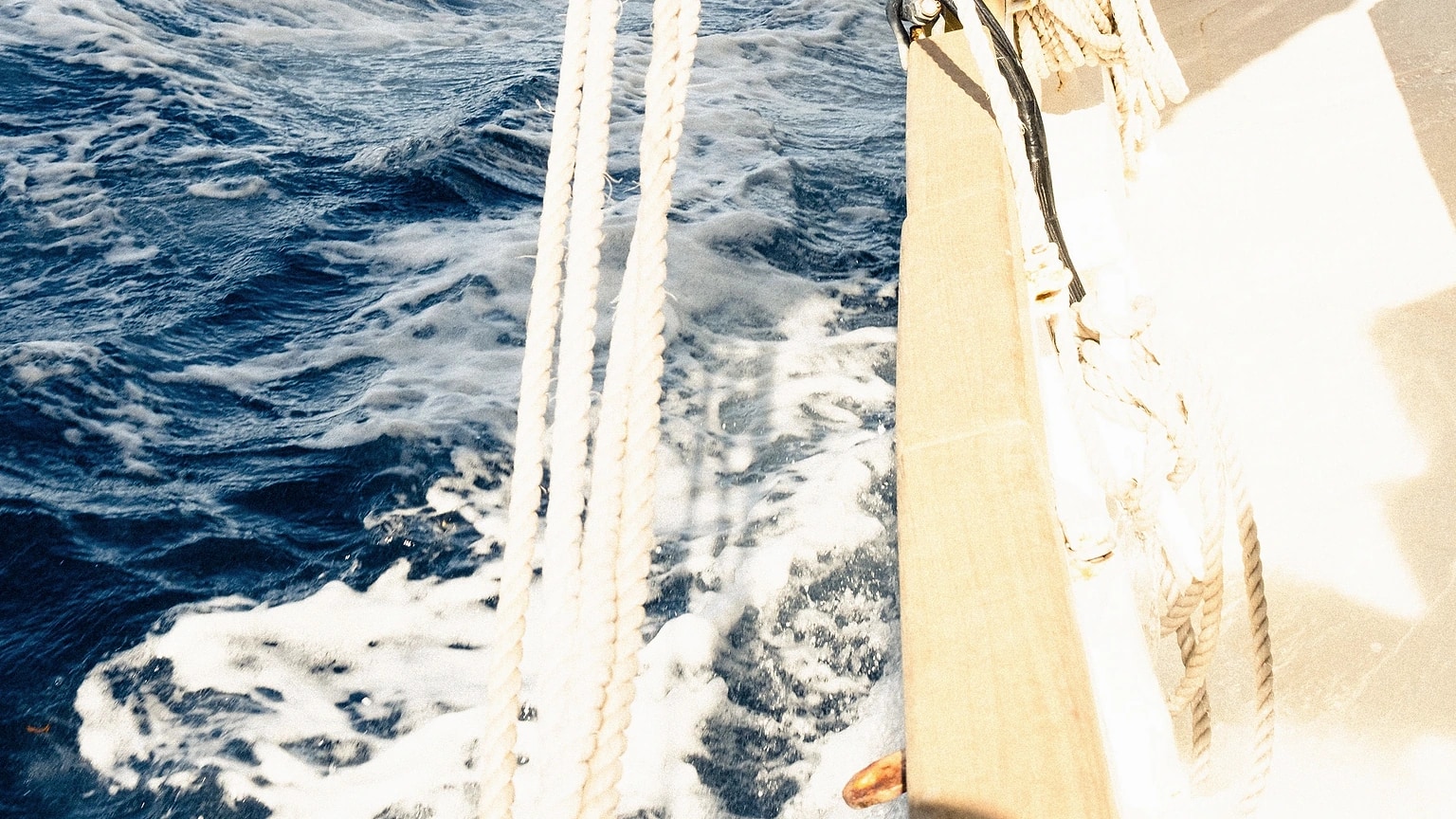 Two sailors working together in a sailboat cockpit