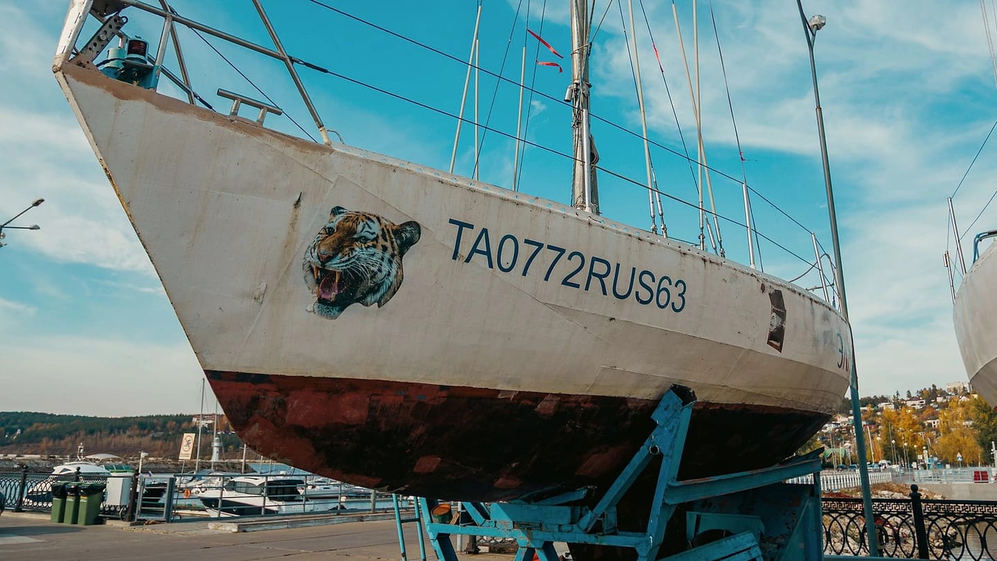 Sailboat standing on supports beneath blue sky