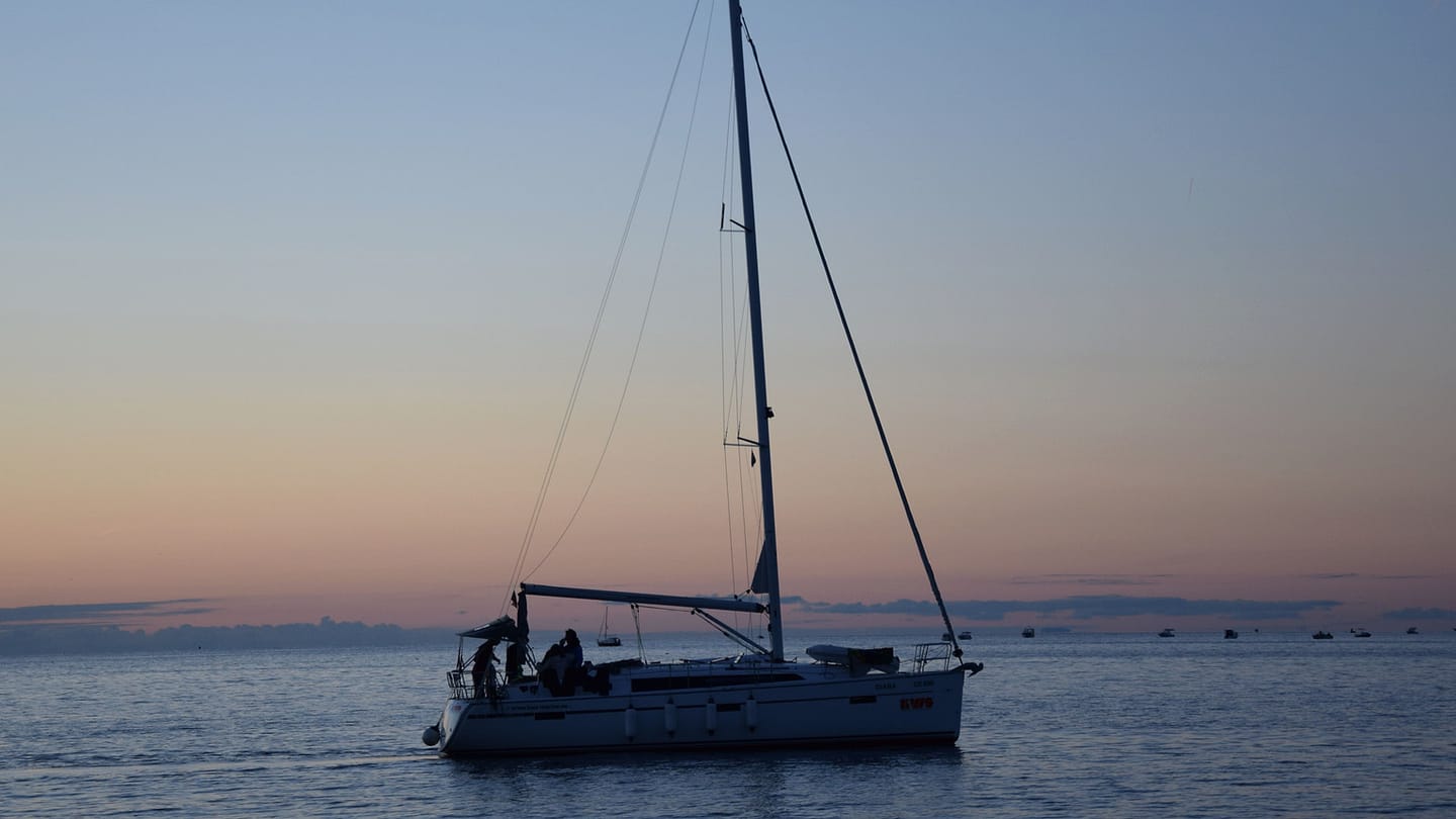 A calm sailboat at dusk shows the quiet conditions a new sailor may choose first.