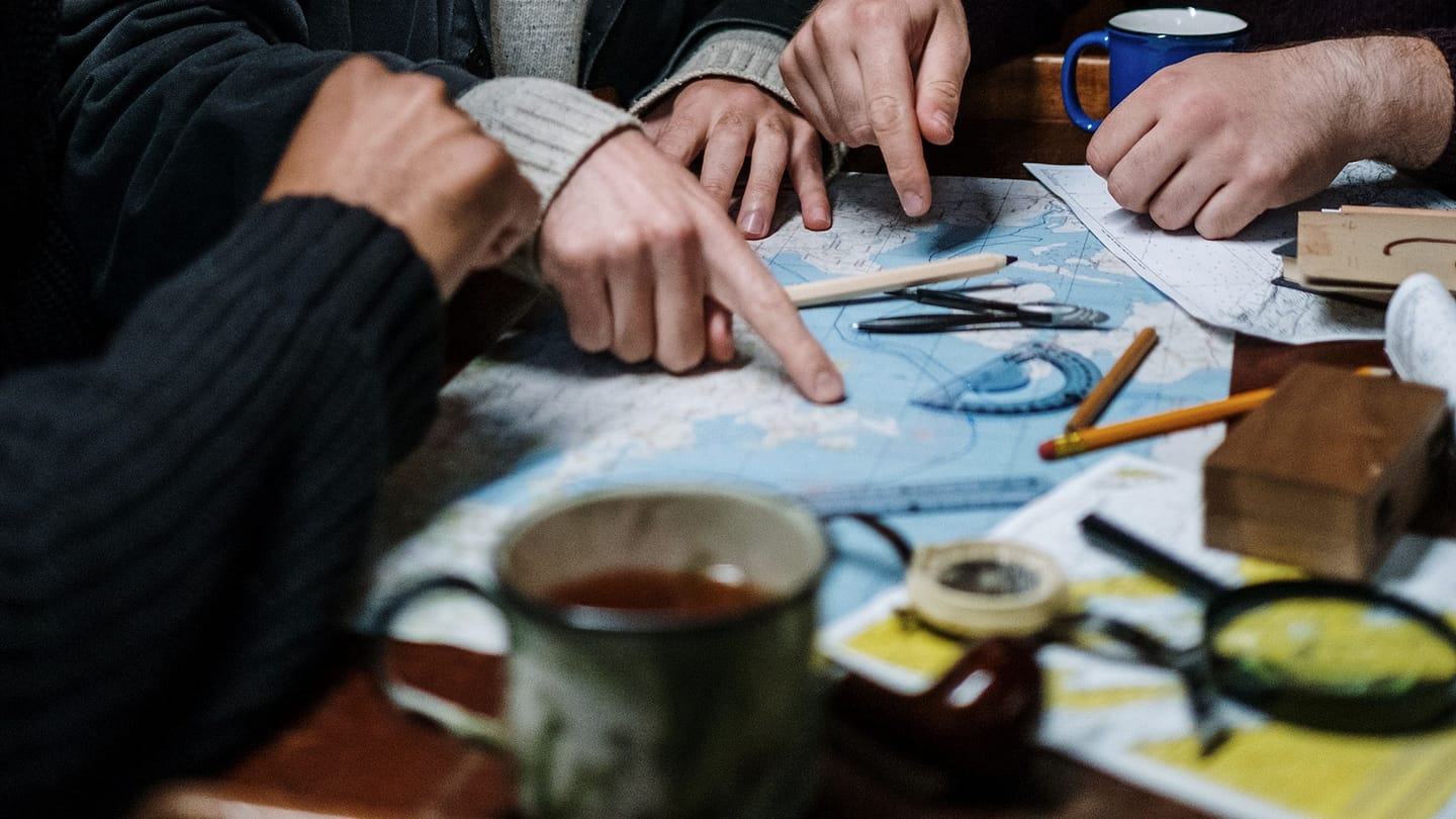 Sailors planning a route over a paper chart