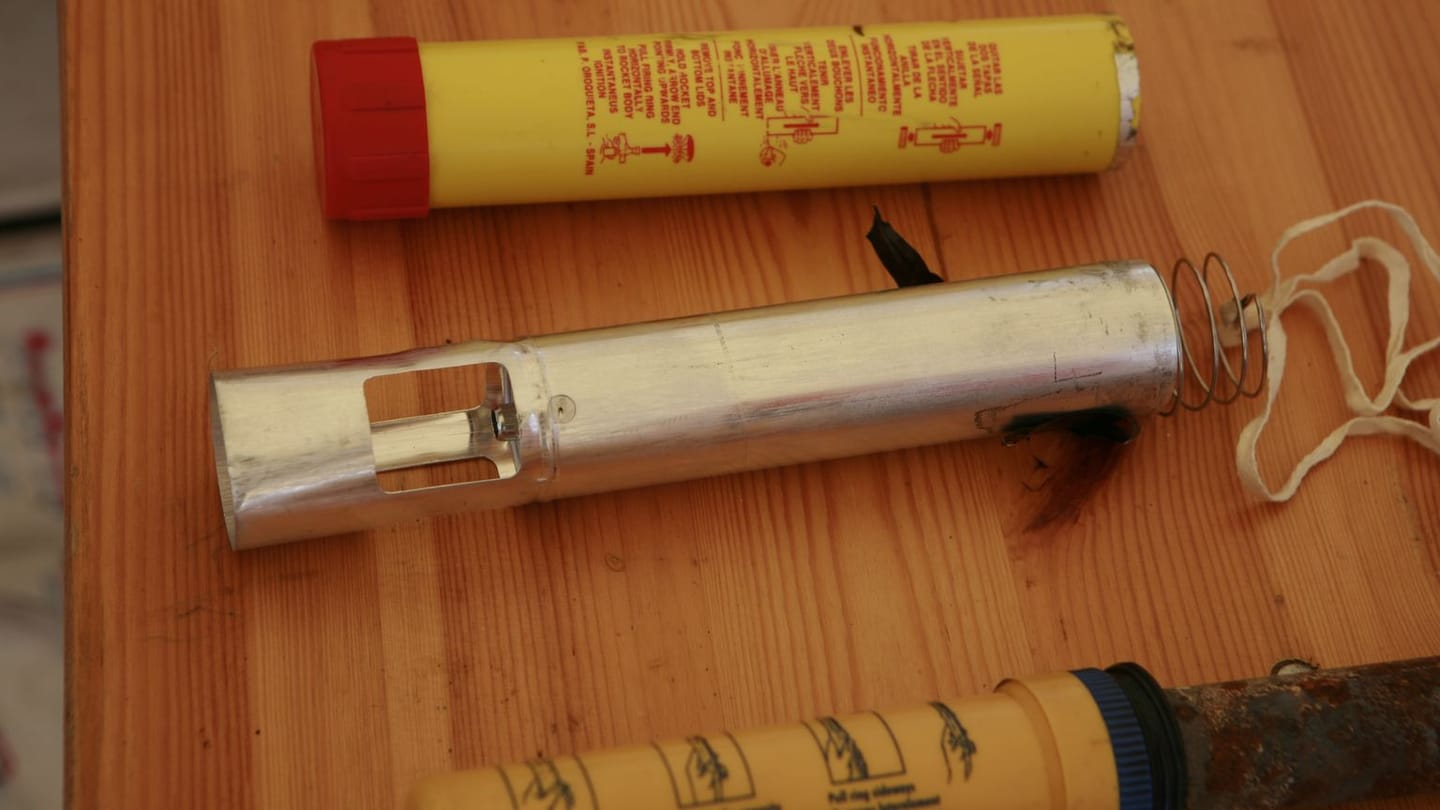 Three real distress flares laid out on a wooden table