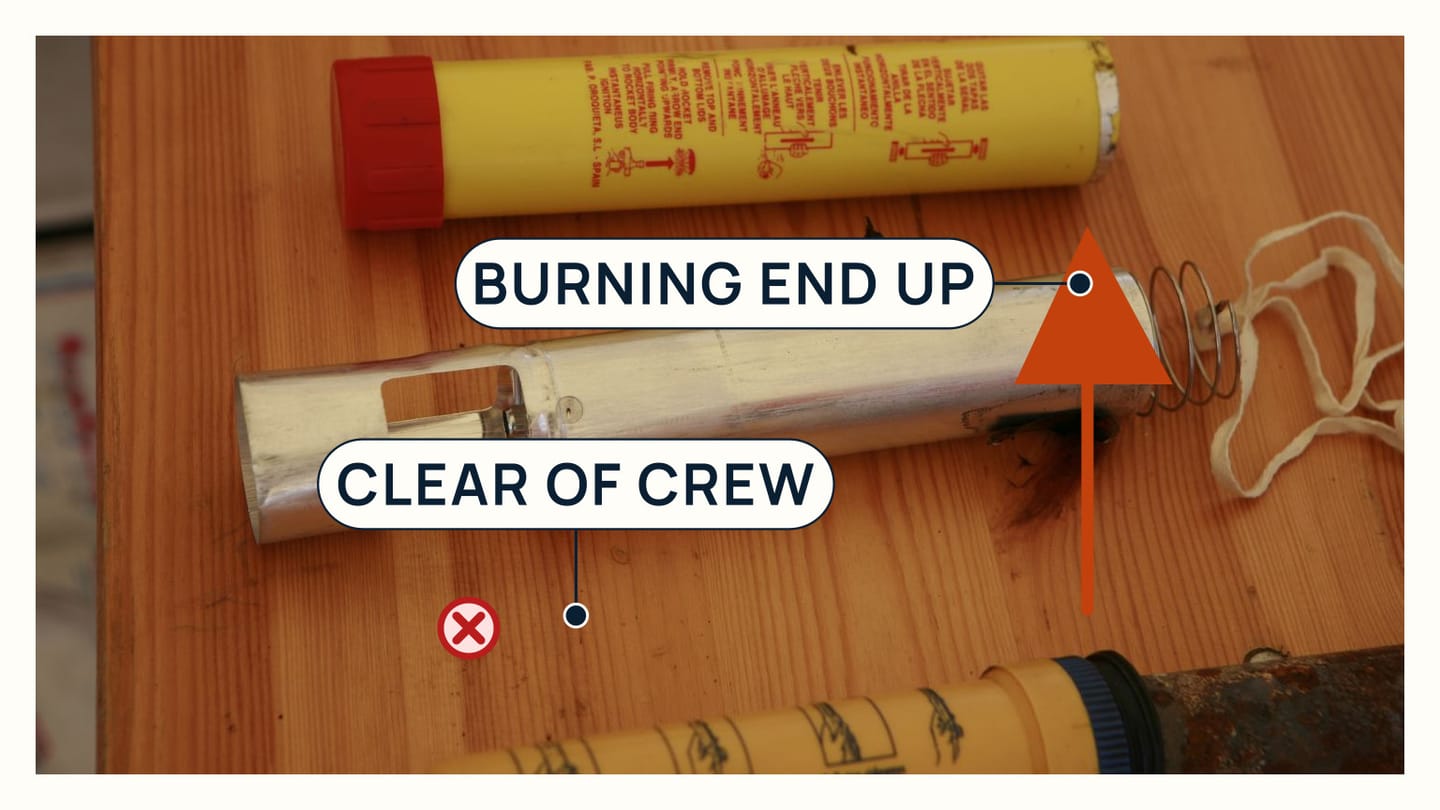A real handheld distress flare marked with the firing end directed up and clear of crew