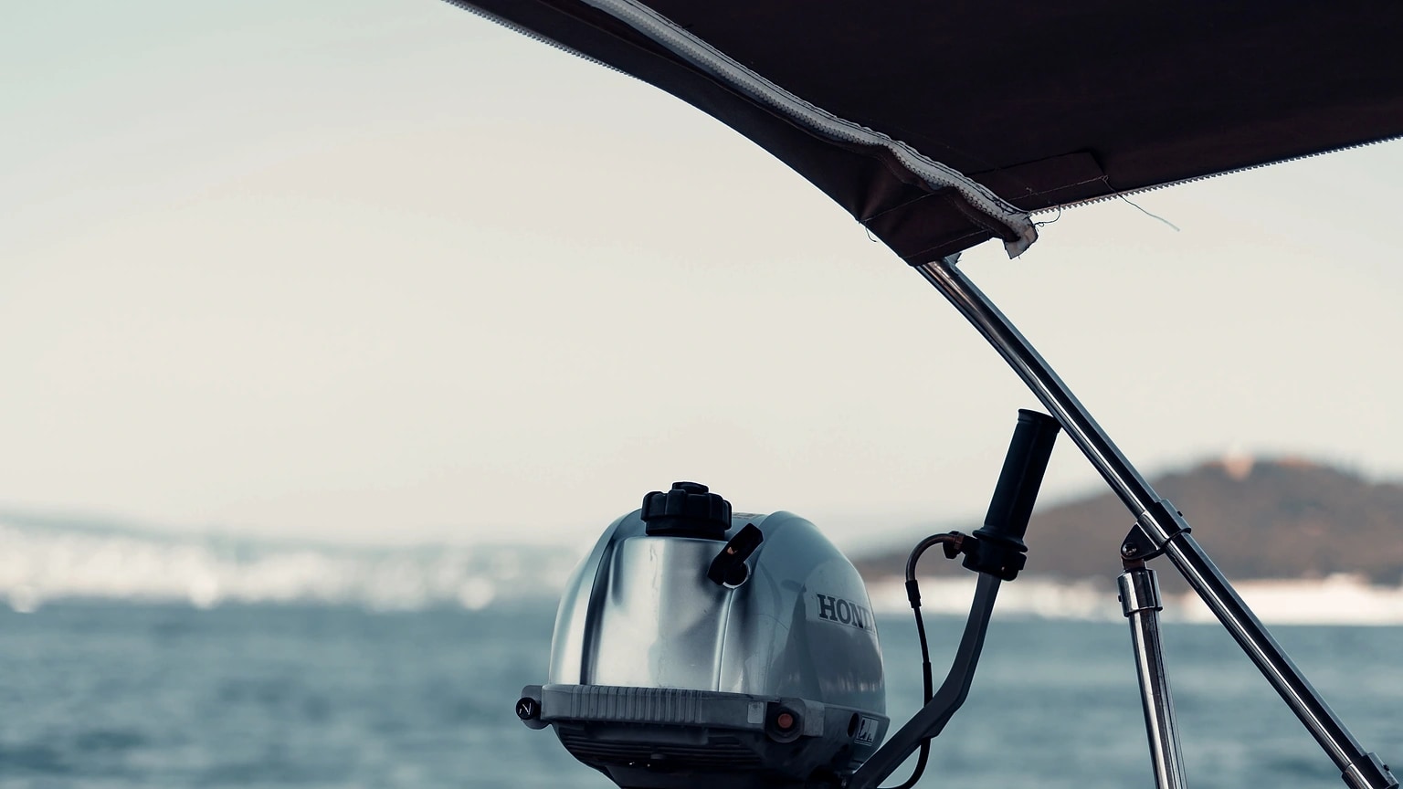 Outboard motor mounted at the stern of a small boat