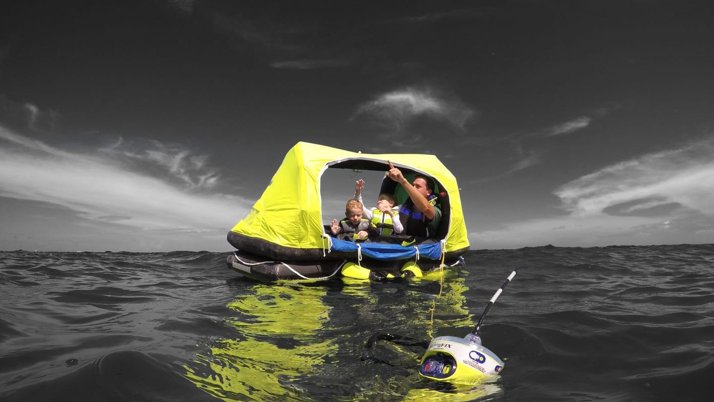 A real EPIRB floating beside a life raft in open water