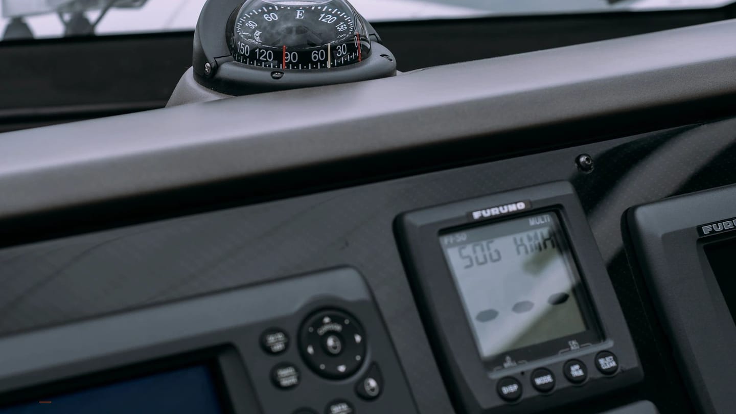 Marine chart display glowing beside helm instruments
