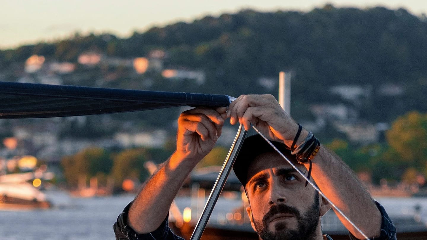 Person adjusting a canopy aboard a moored boat