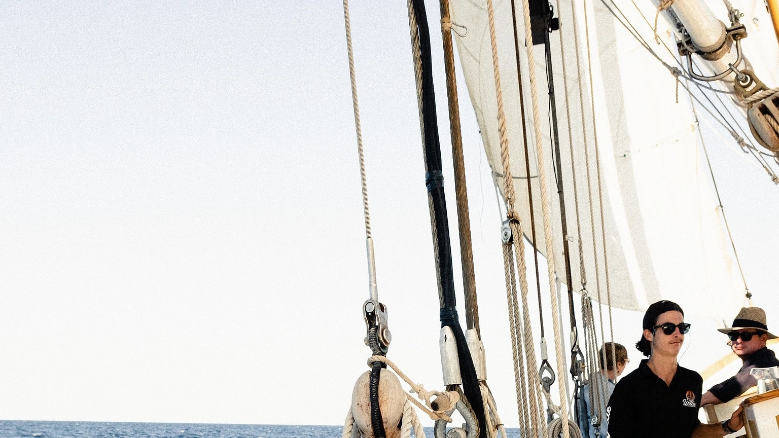 Sailors standing together on the side deck of a sailboat