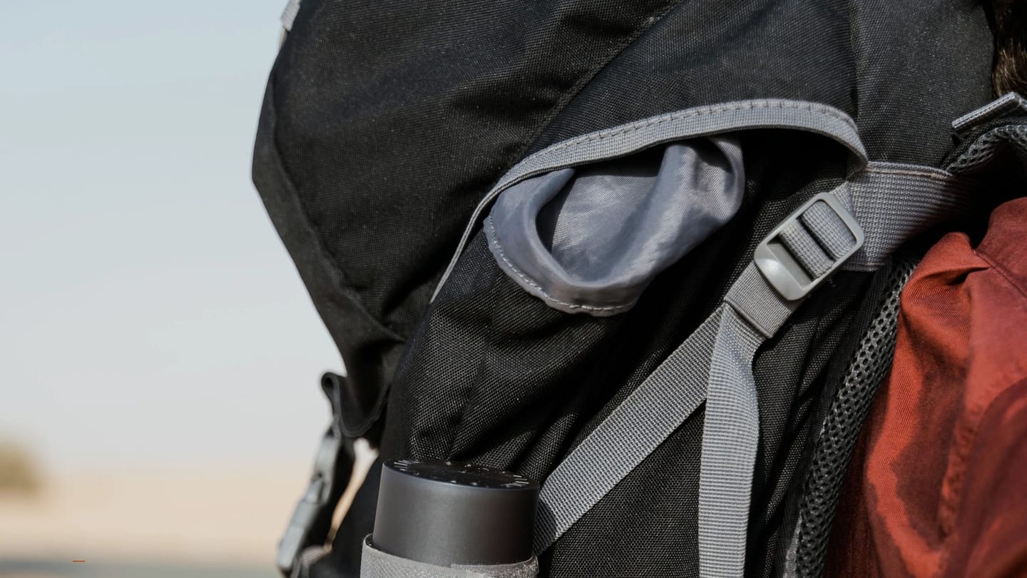 Reusable water bottle attached to a compact gear bag