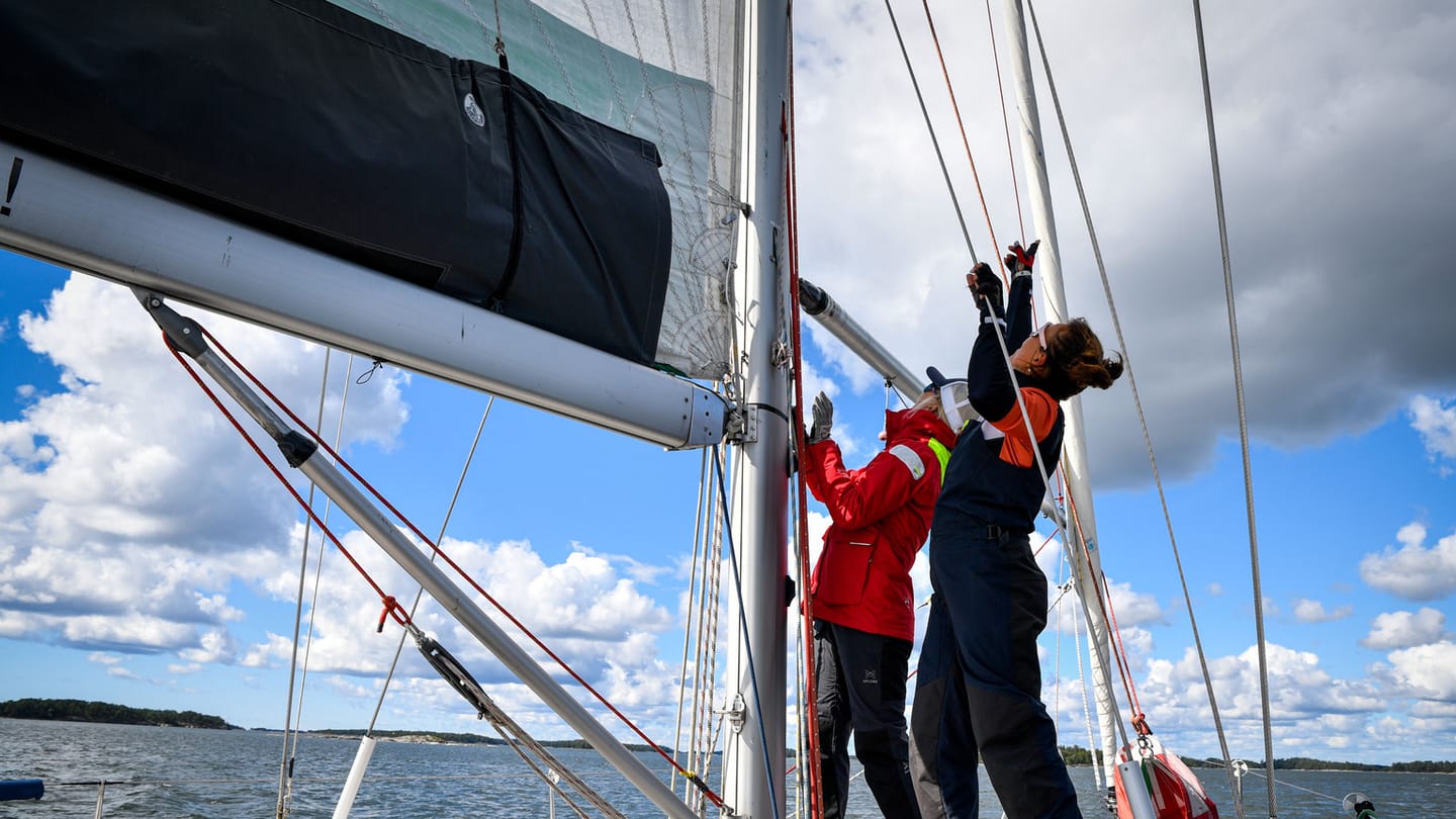 A sailing crew working aboard a monohull in open water