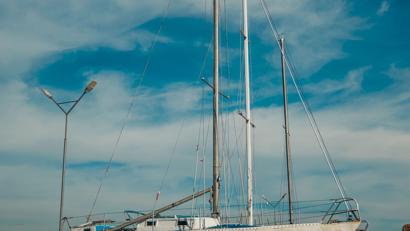 Sailboat mast and standing rigging viewed from below against a blue sky