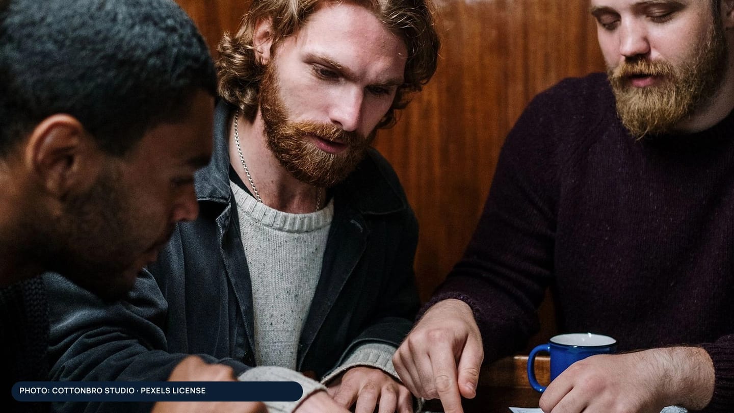 Three people leaning over a table during route planning