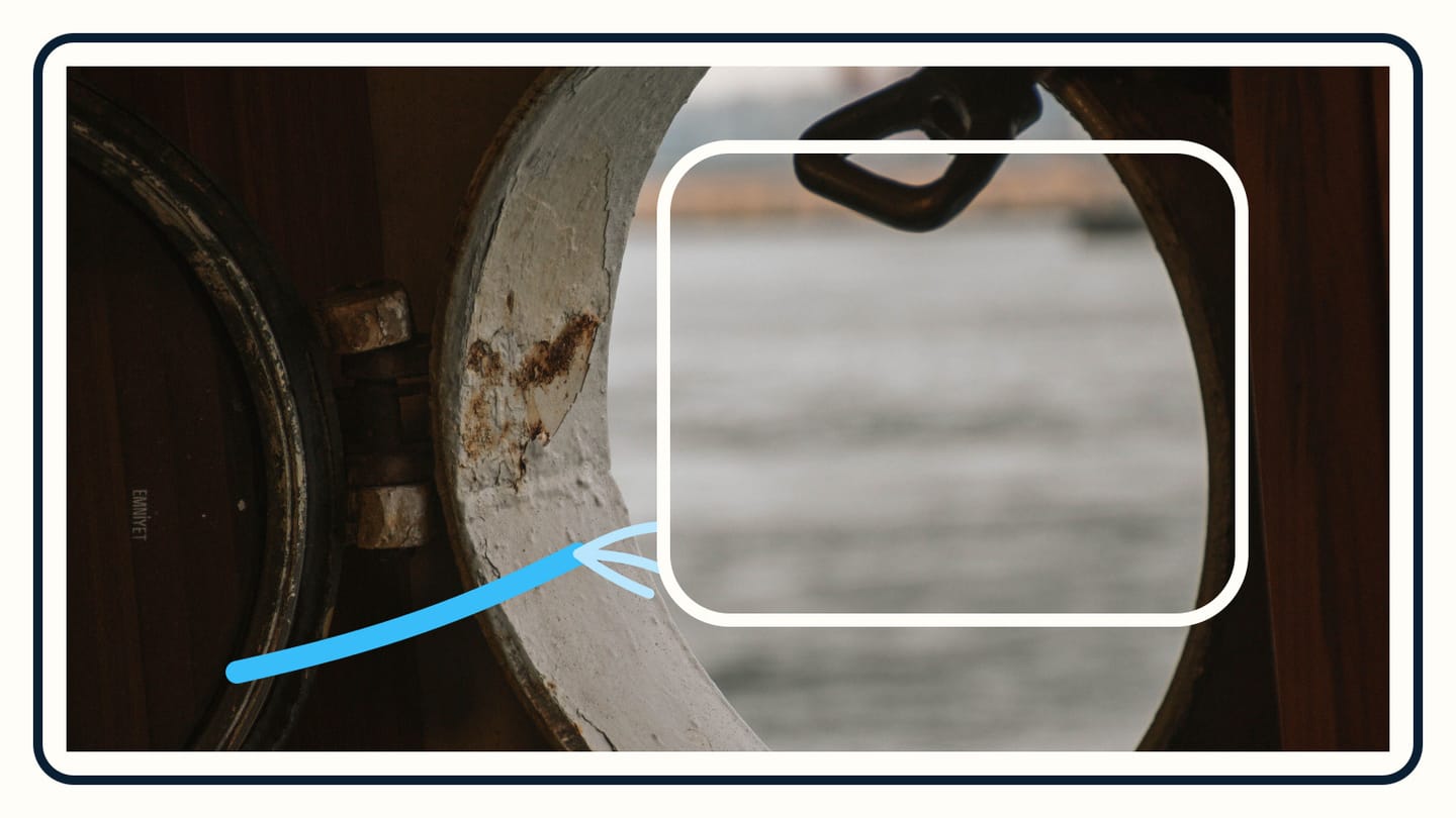 A narrow blue test stream reaches one lower corner of an oval portlight while the remaining frame stays clear.