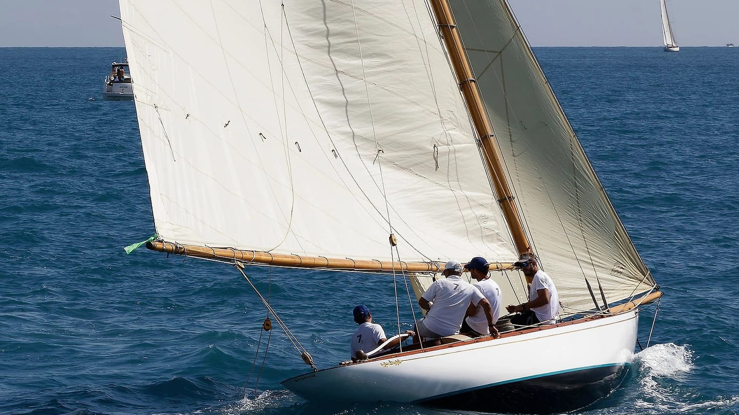 Sailboat moving under white sails