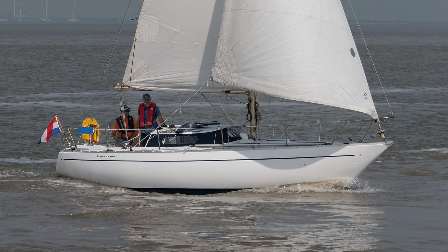 A sailboat moves alone on open water with room to practise a controlled pause.