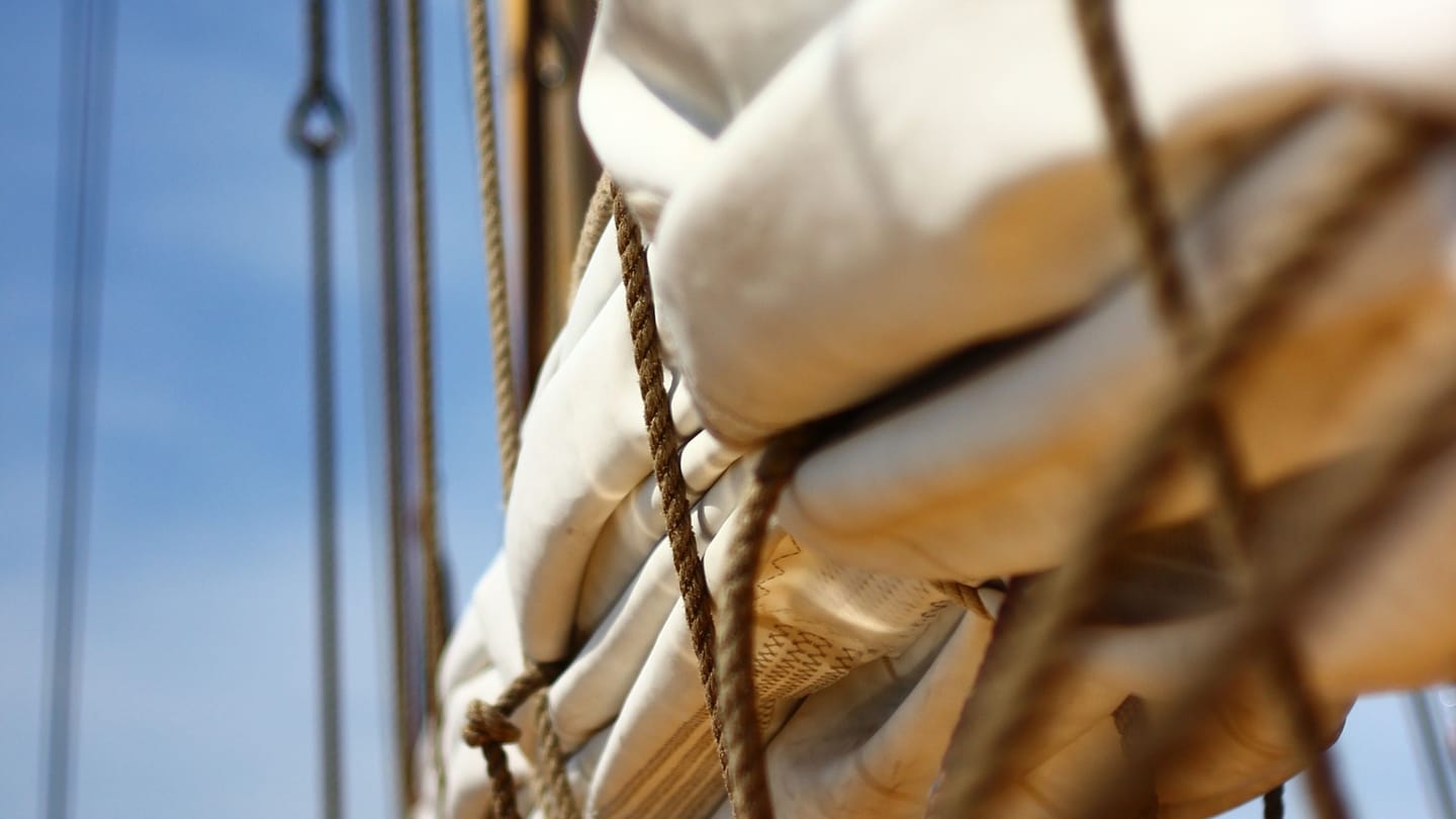 A close view of a sail edge and bundled sailcloth