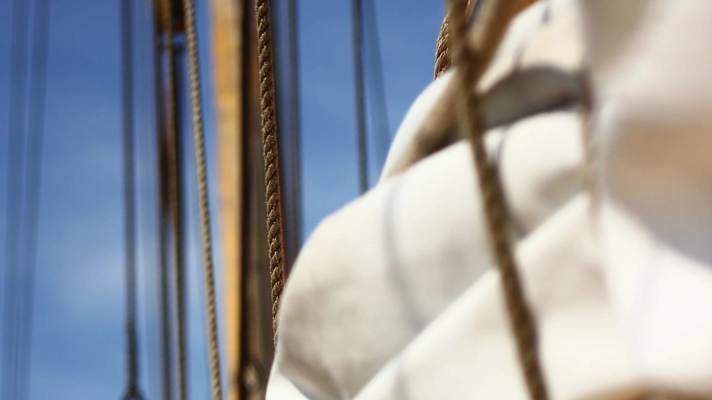 Folded tan sailcloth and rope on a sailboat