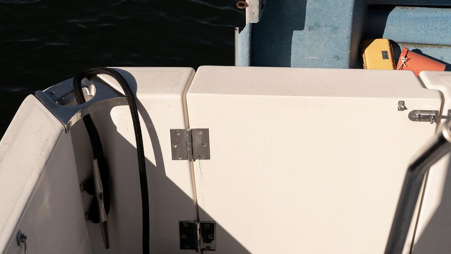 White boat deck in sunshine beside calm water