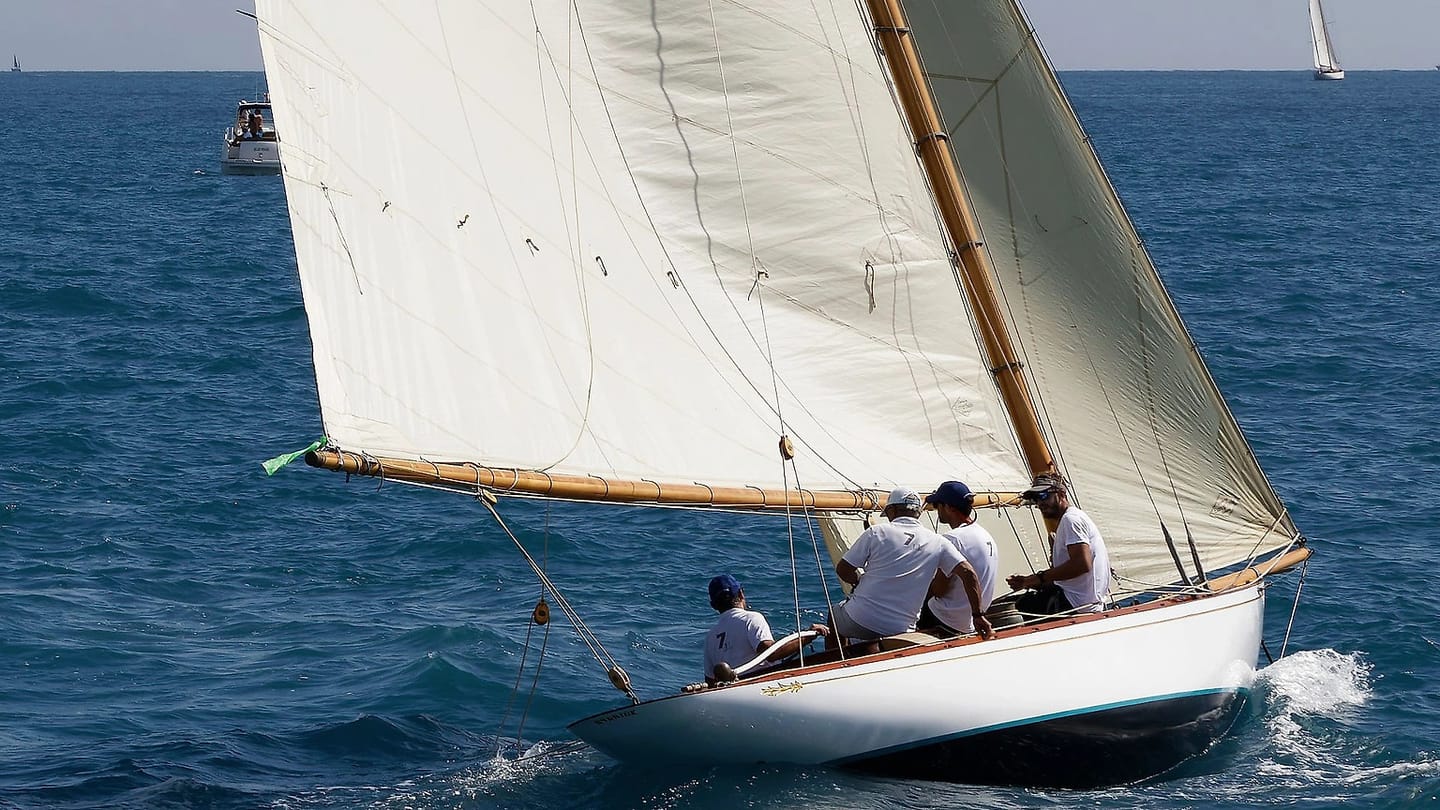 Sailboat carrying white sails in a blue sea