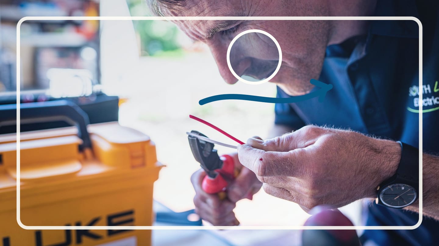Technician working beside bundled electrical cables and distribution equipment