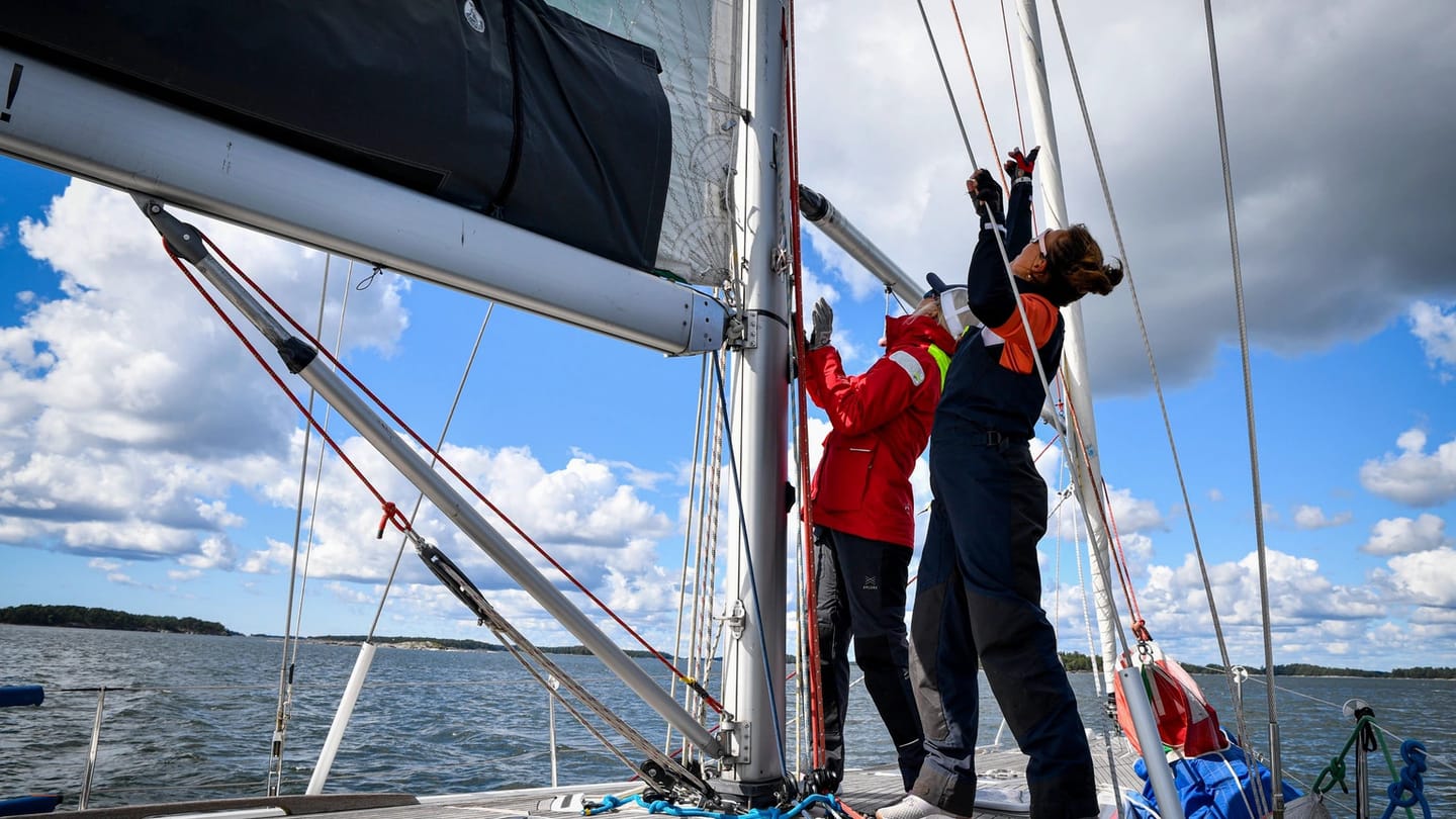 Several sailors working together in the cockpit of a yacht