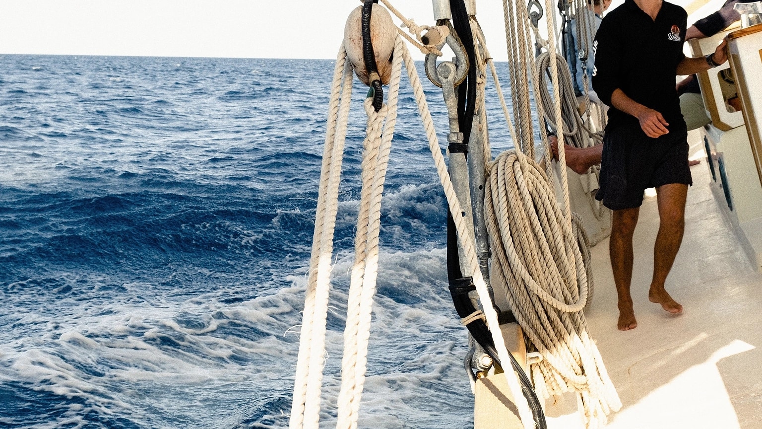 Sailors standing together on the side deck of a sailboat