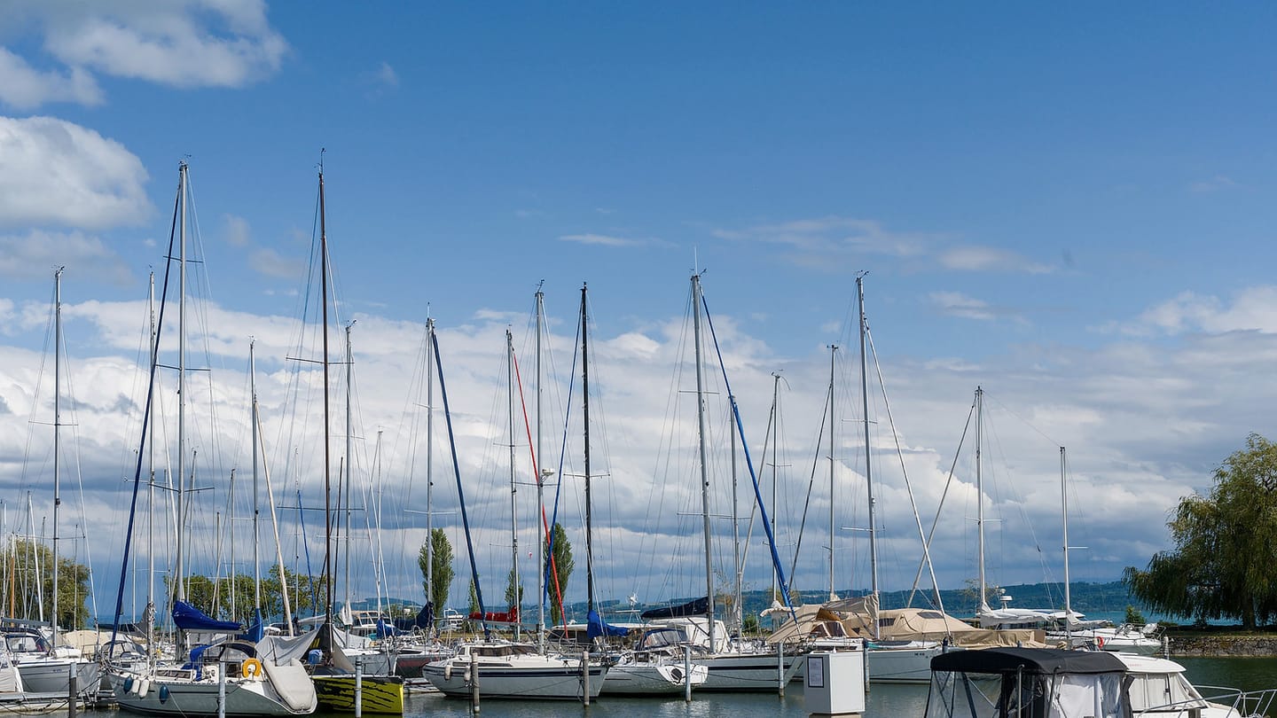 Dark clouds build beyond sailboats secured in a marina.
