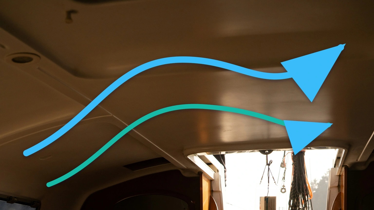 Blue airflow arrows cross the overhead lining and open companionway of a sailboat cabin