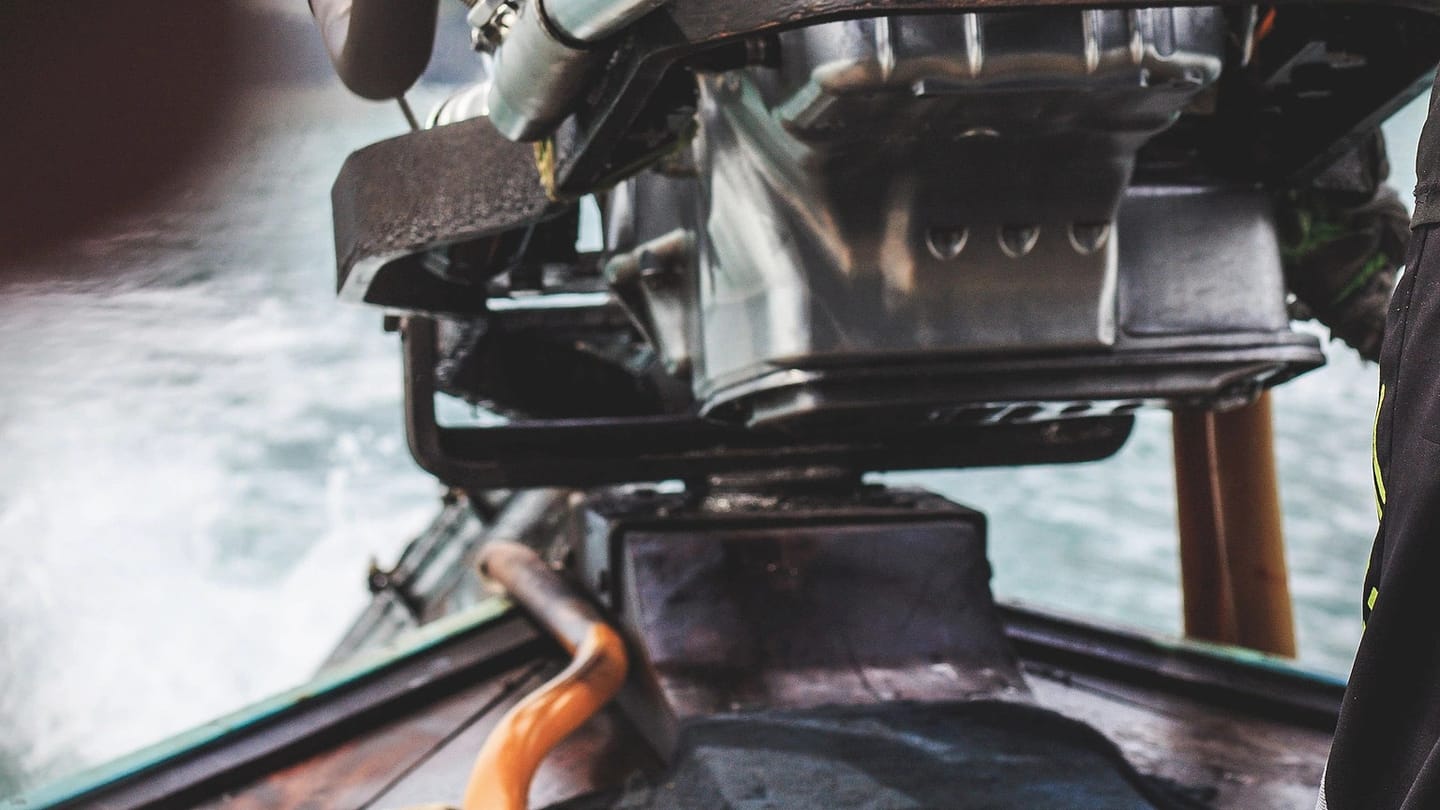 Mechanic handling an engine aboard a boat