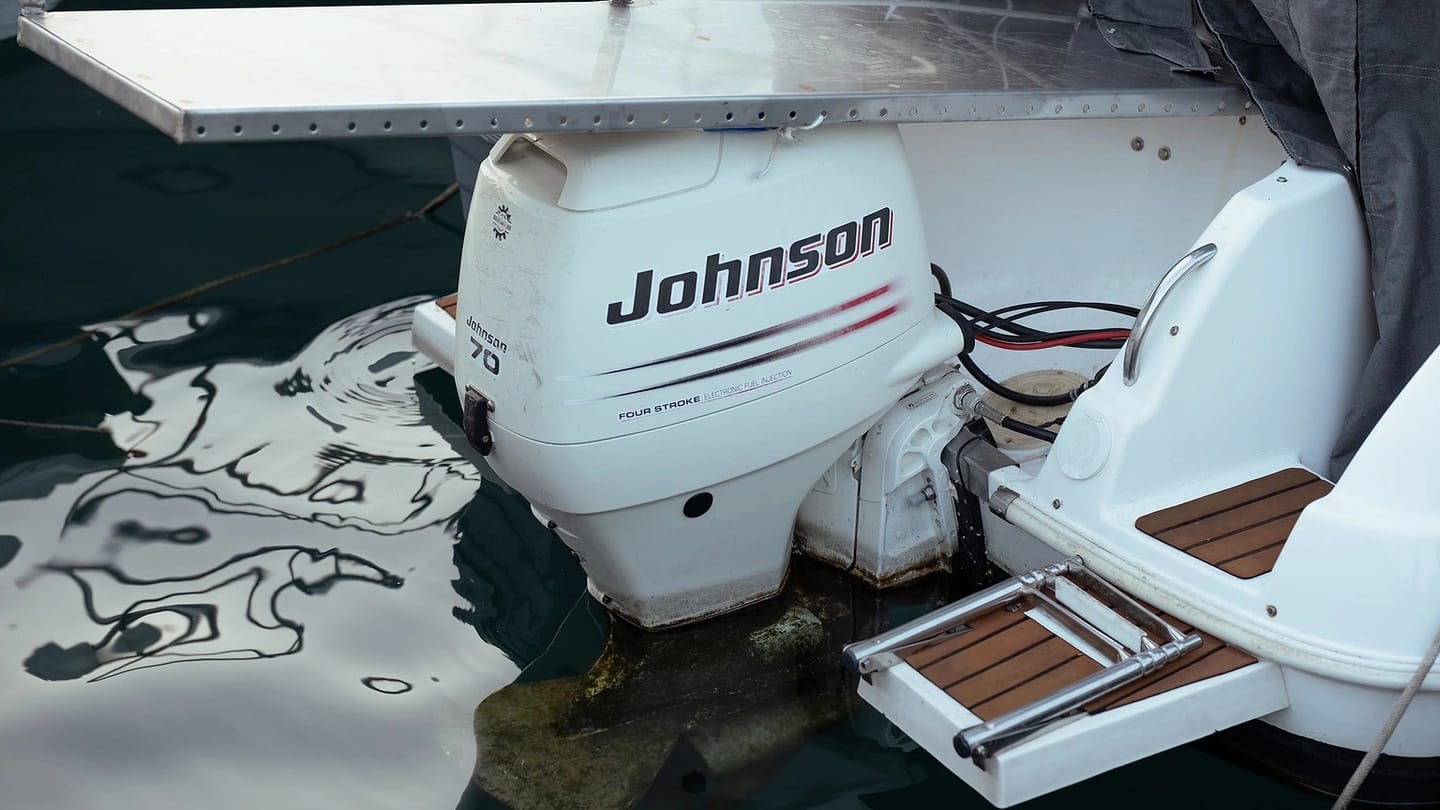Close view of an outboard engine beside water