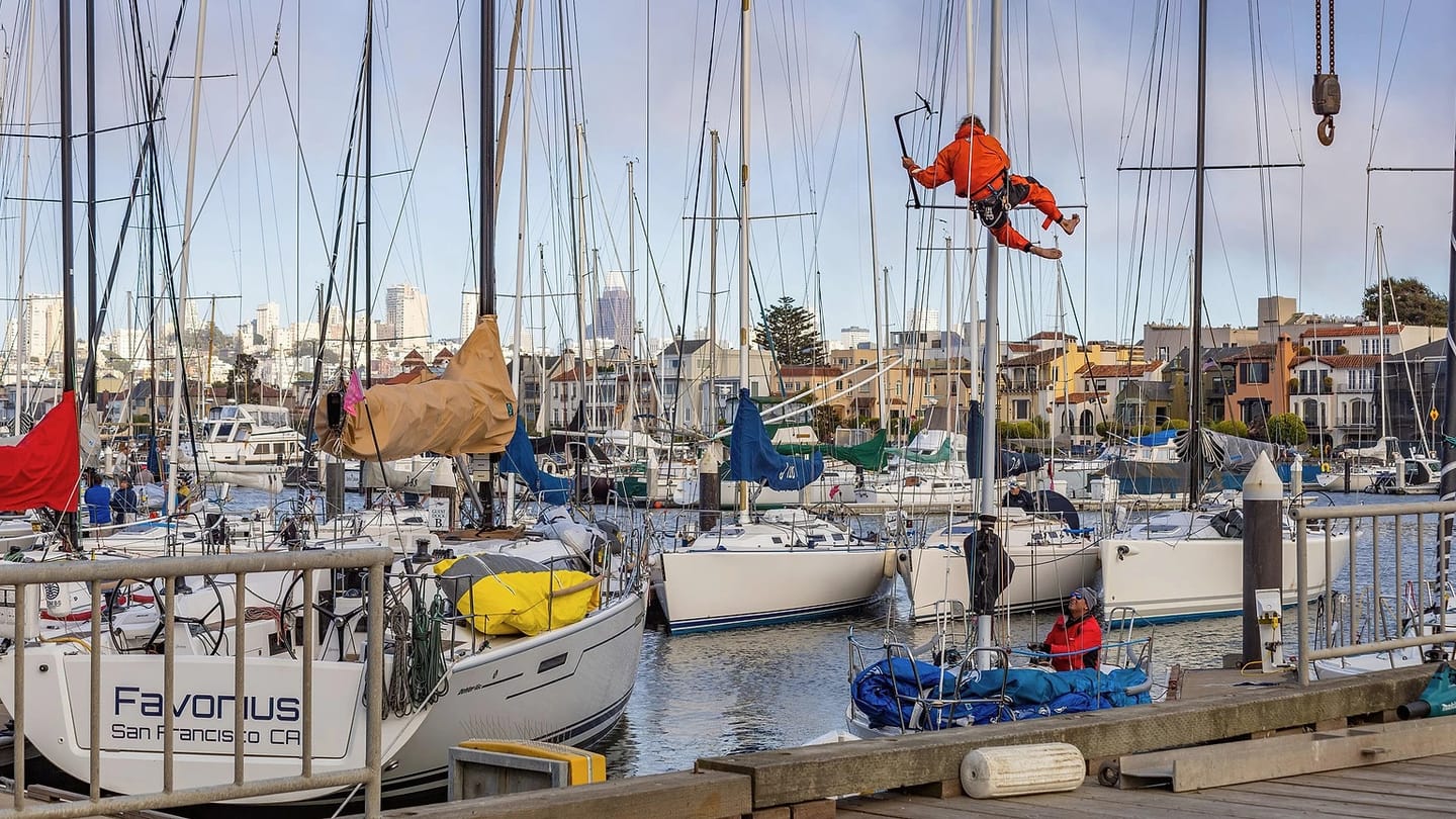 Person working on a sailboat at a marina