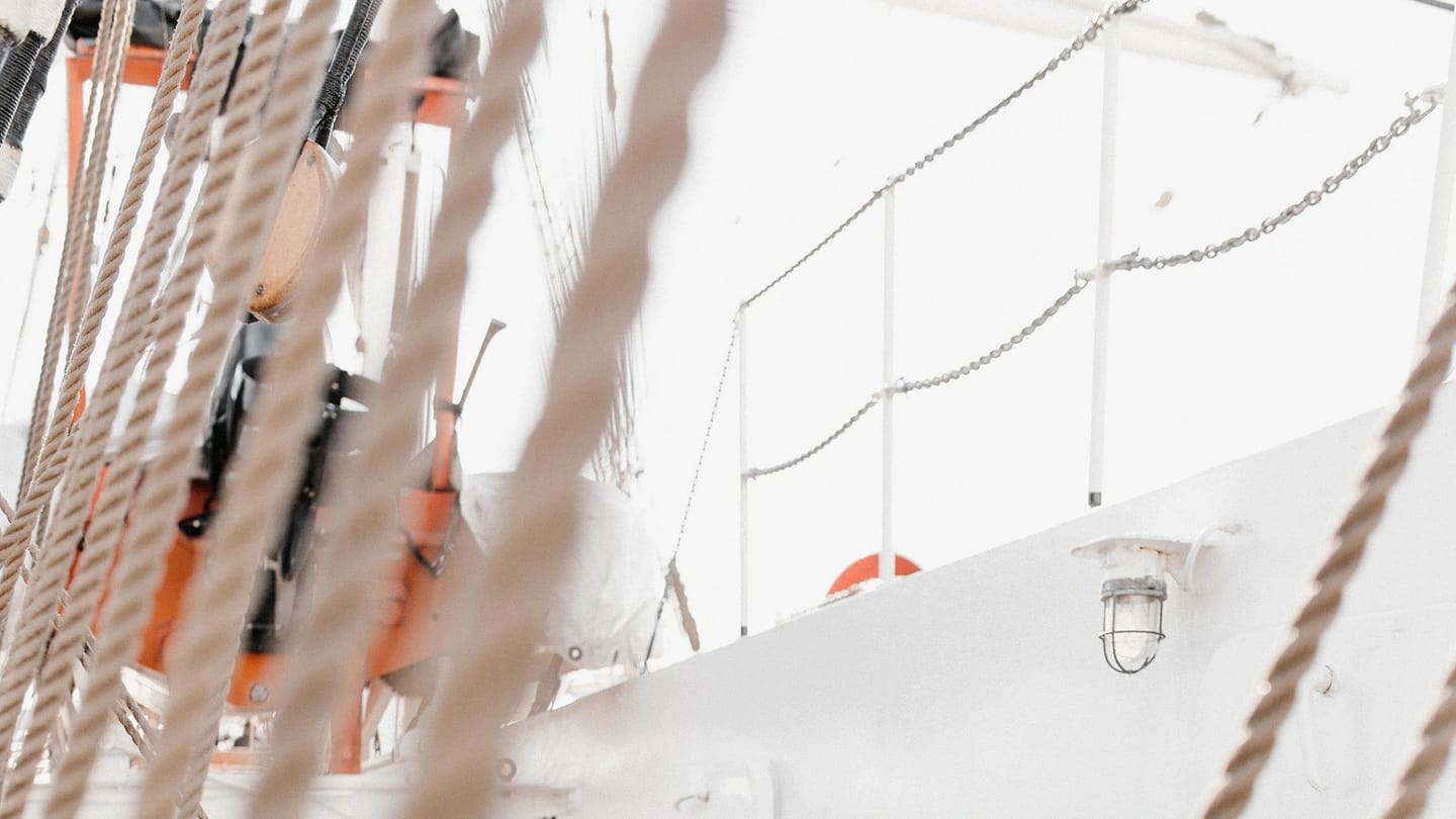 Sailor handling rigging aboard a vessel