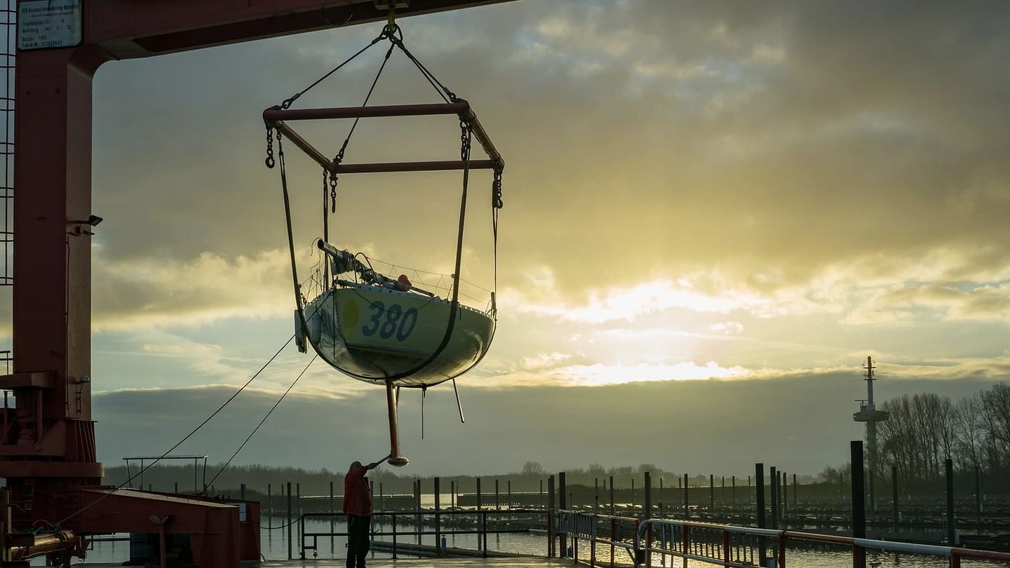 Sailboat suspended in lifting slings at a harbor