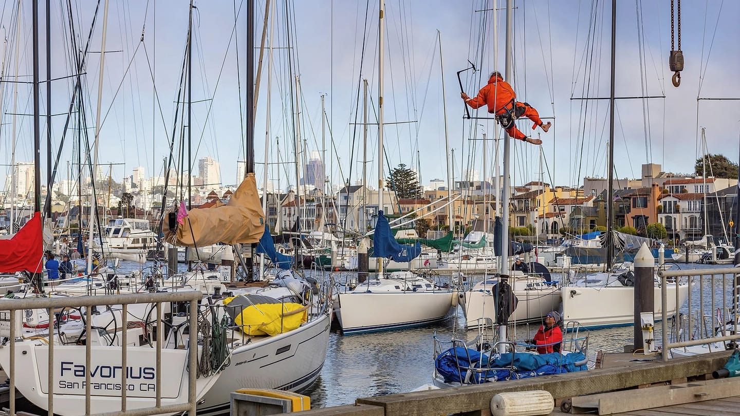 Technician examining a sailboat at a marina