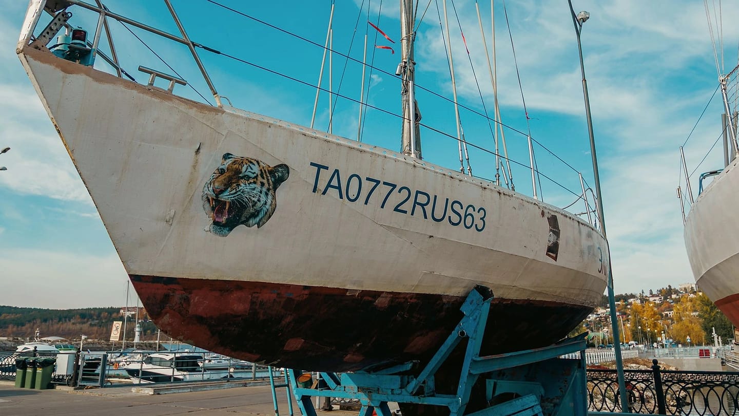 Sailboat stored ashore beneath a clear sky