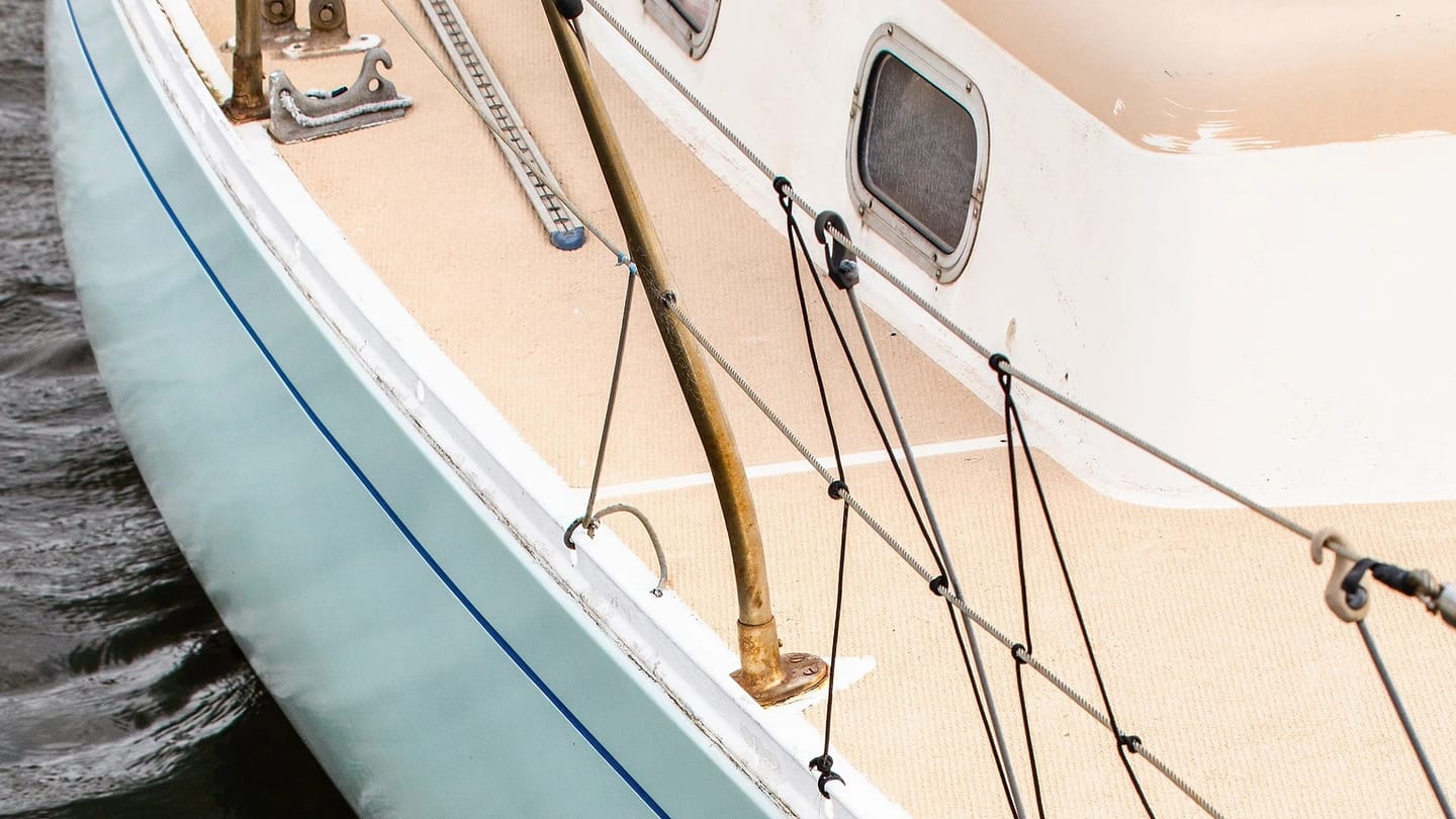 White sailboat moored alongside calm water