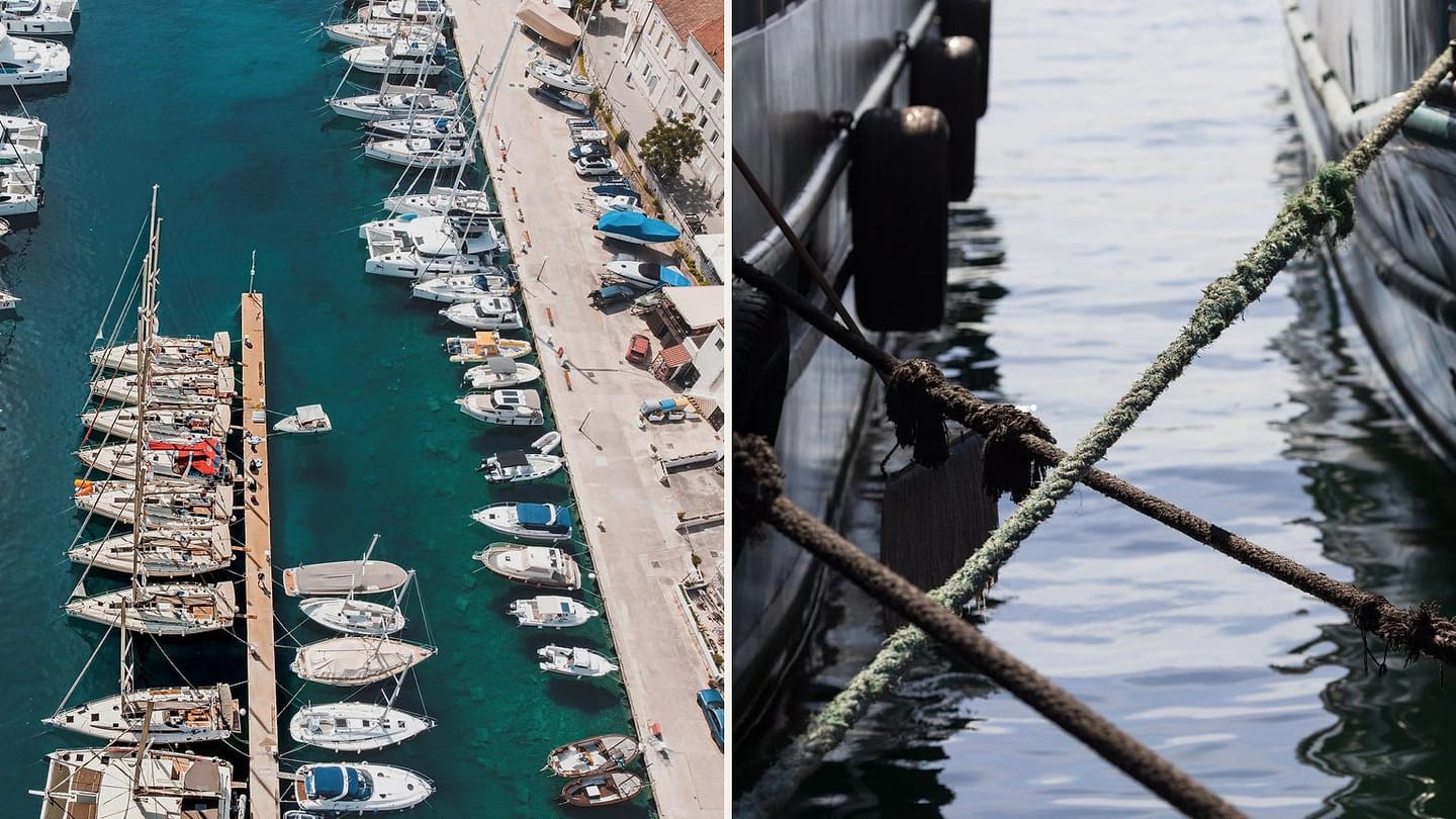 Aerial marina berths beside crossed dock lines between boats