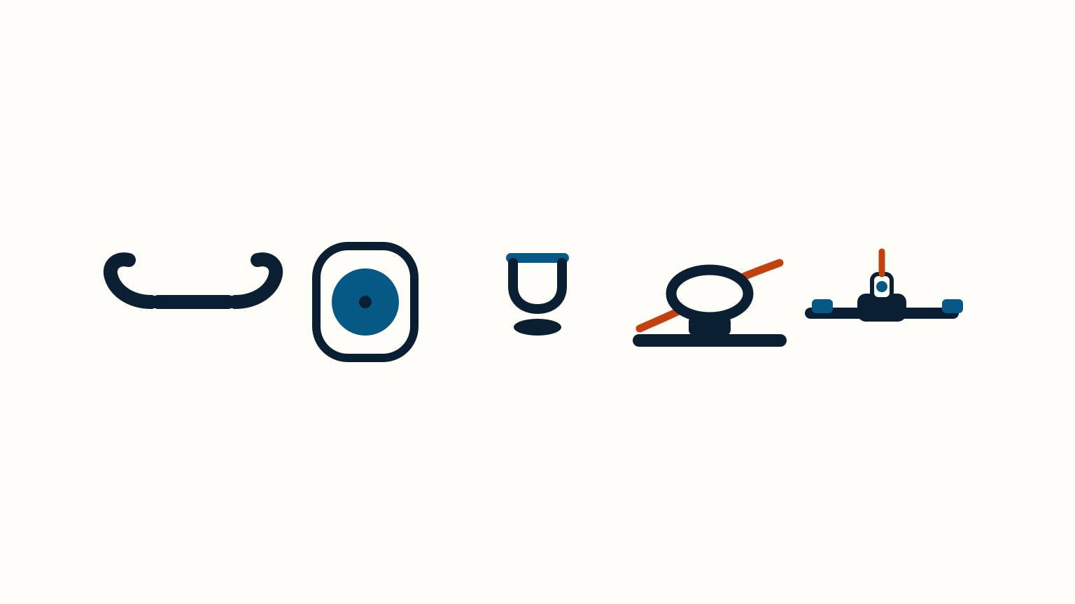 A flat-lay of small sailboat deck hardware on a workbench: a horn cleat, a block, a D-shackle, a fairlead ring, a rope clutch, and a traveler car on its track