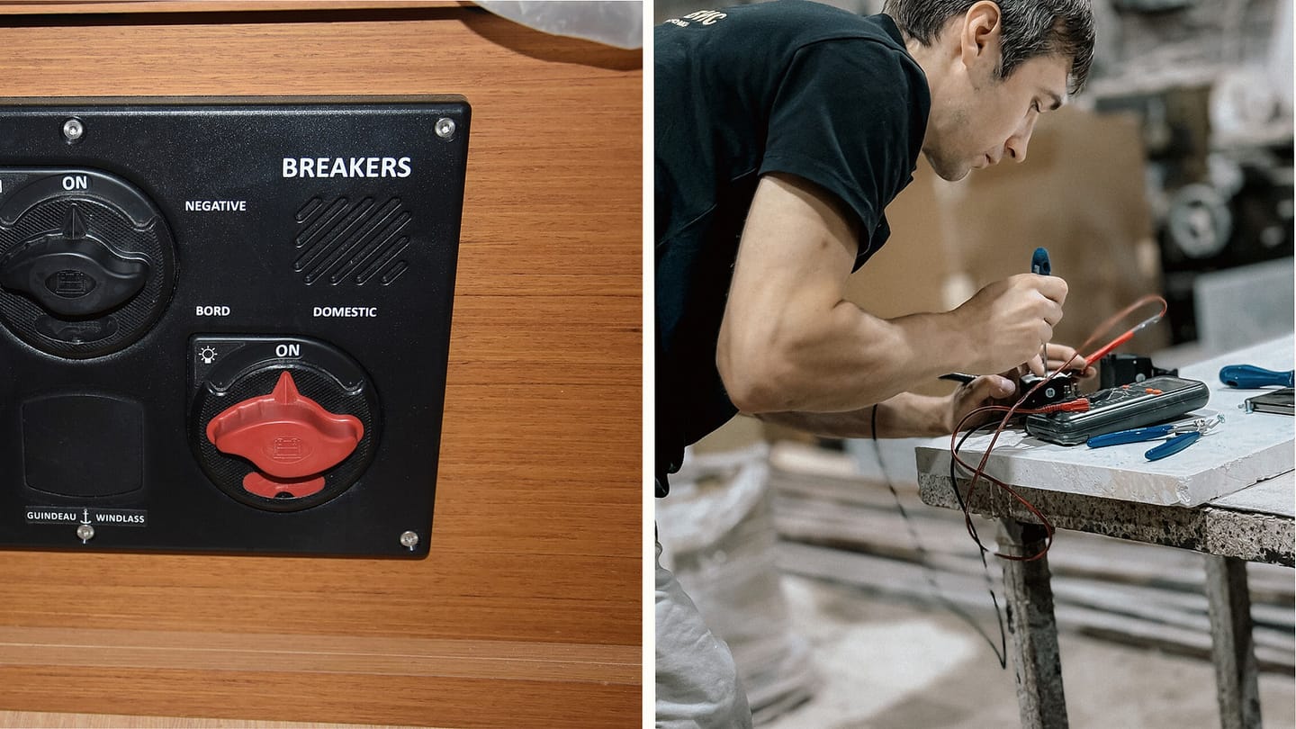 Main sailboat battery switches beside a technician using a multimeter