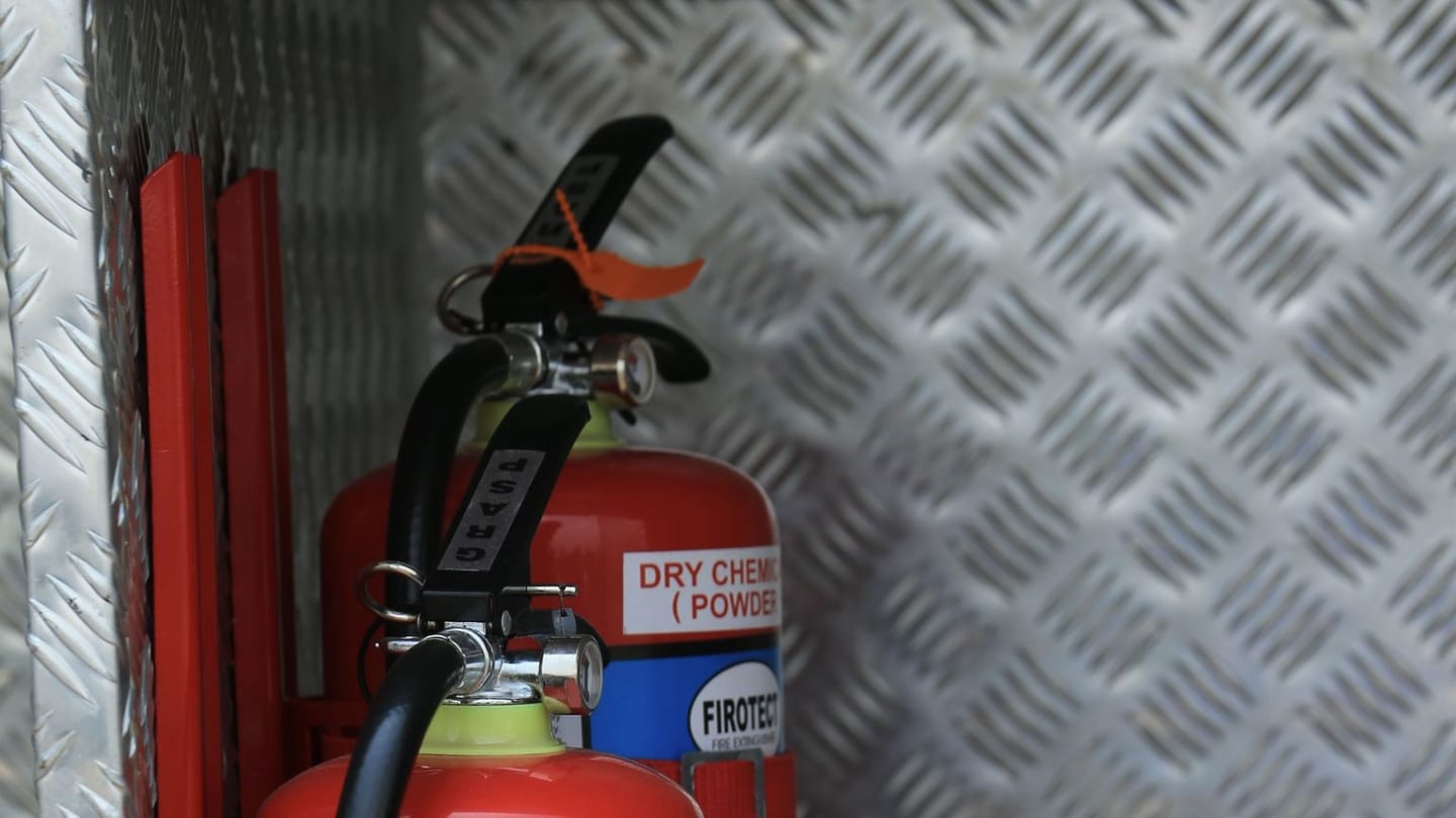 A red fire extinguisher partly visible in a dark storage space