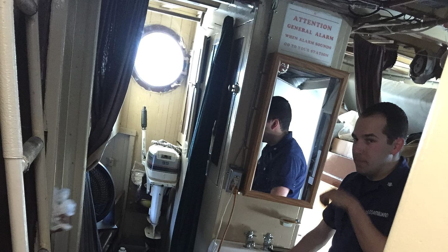 A crew member beside a compact boat sink