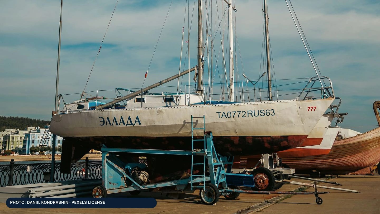 A sailboat supported ashore on a boatyard cradle