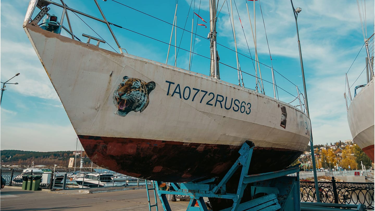 Sailboat ashore with its keel visible below the hull