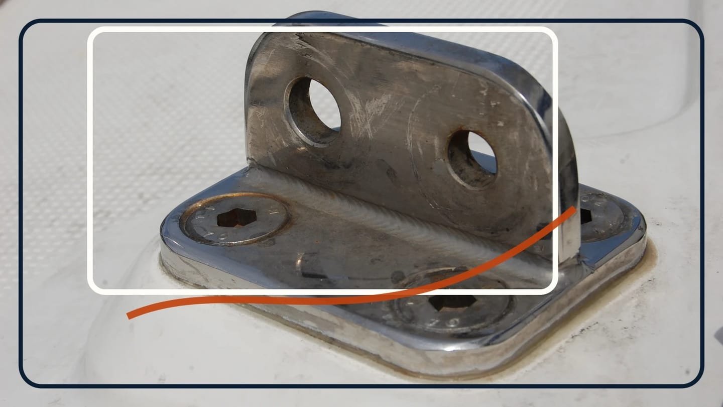 Stainless stanchion socket on a white deck with the post removed, exposing two wire holes and four base fasteners.
