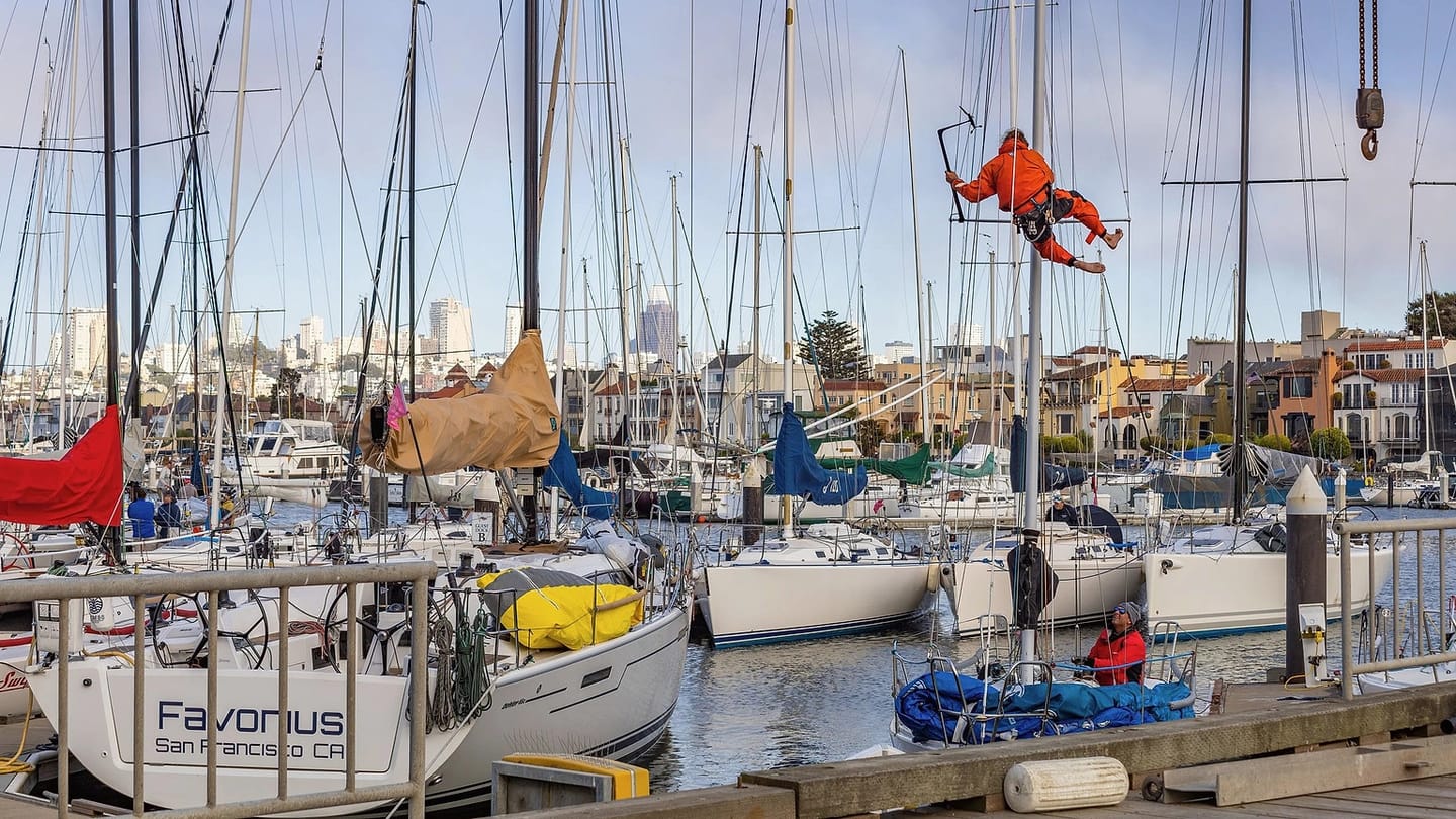 Technician working beside sailboats in a marina