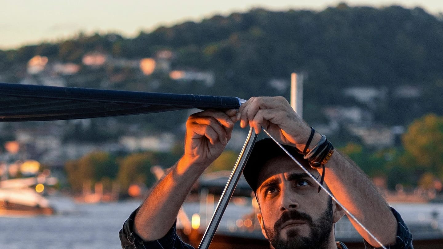 Person adjusting equipment on a boat at the dock