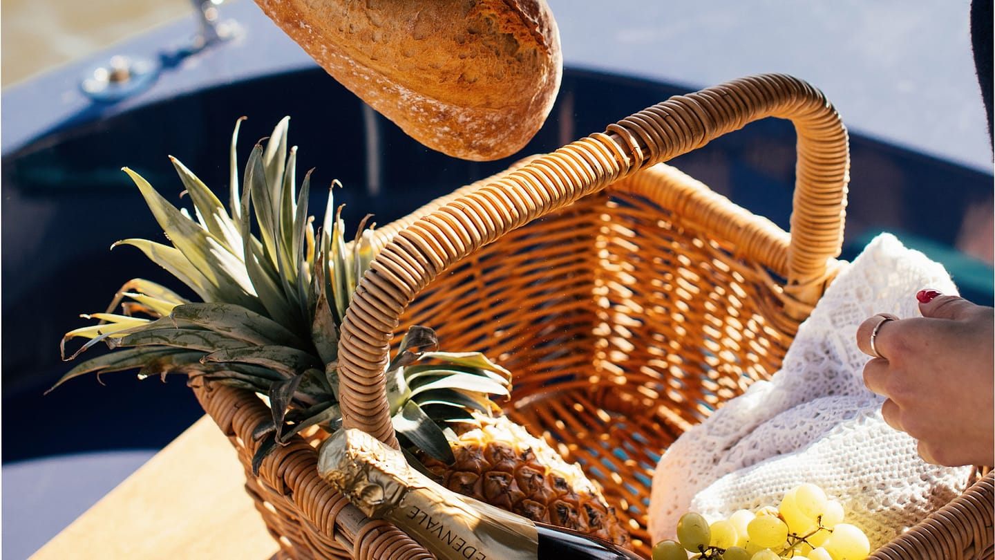 Basket of bread and fruit being unpacked on a boat