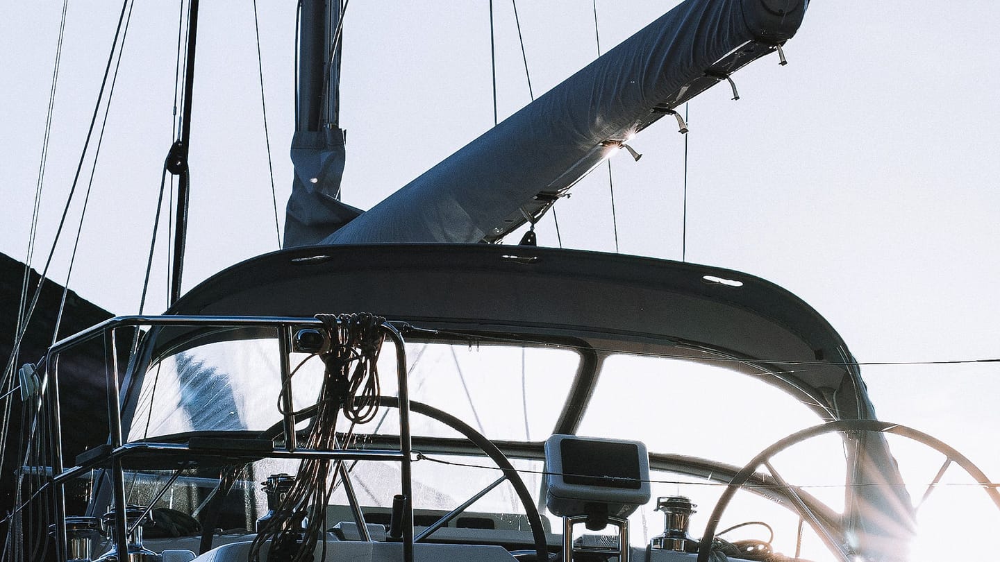 A white sailboat lies alongside a dock with its deck and mast visible.