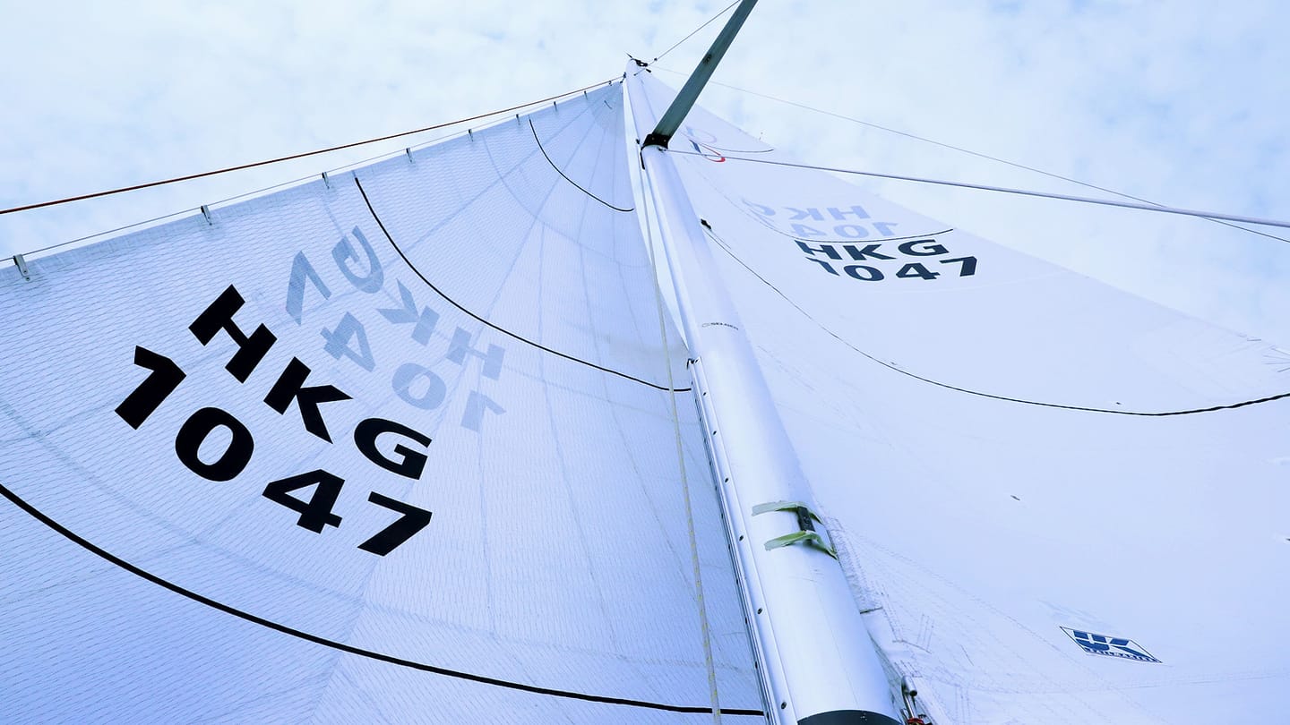 A close view shows a white sail drawing above a sailboat deck.
